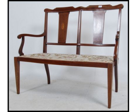 An Edwardian mahogany inlaid two seat sofa Settee. Mahogany inlaid tapered frame united by stretchers having shaped elbow res