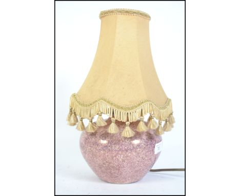 A 1930's lustre ceramic table lamp of bulbous form marked to the base CH France. Complete with the shade. 37cms high