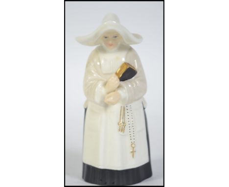 A royal Worcester candle snuffer in  the form of a nun. Stamped to the inside