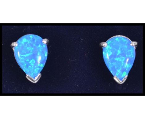 A pair of ladies silver pear shaped blue opal stud earrings complete in a presentation case