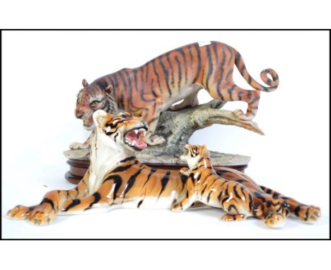 Two ceramic figurines of tigers. The first being an Italian made recumbent mother and her cub stamped to base and the other o