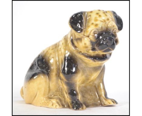 A ceramic 19th century Victorian Staffordshire figurine of a Pug dog.  Treacle glazed, of large form with some texture to bod