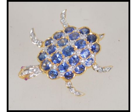 An 18ct gold sapphire diamond and ruby figural brooch pendant in the form of a turtle having articulating legs tail and head.