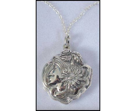 A silver Art Nouveau style locket with rococo decoration in relief set to a silver chain. Complete in the case. Total weight 