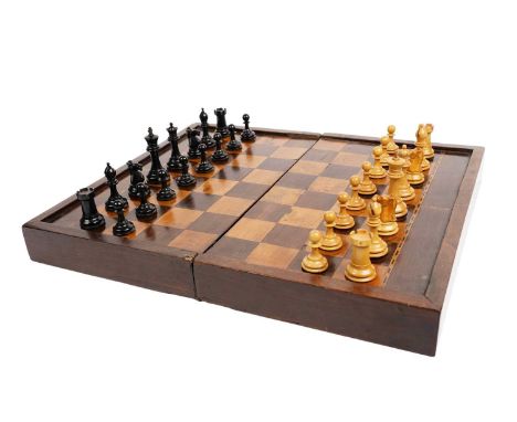 An early 20th Century rosewood and mahogany games box, the exterior representing a chess board with alternating squares, the 