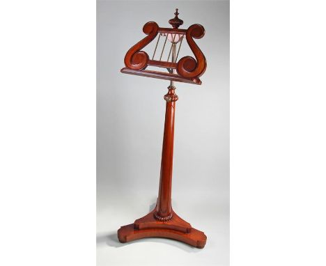 Regency style music stand, with a harp adjustable music sheet shelf above a column and platform base