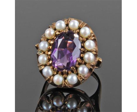 Yellow metal stone and pearl set ring, with central purple stone, flanked with pearls, ring size P