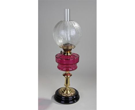 Victorian oil lamp, the etched shade above a cranberry glass font, brass canted column, 64cm high