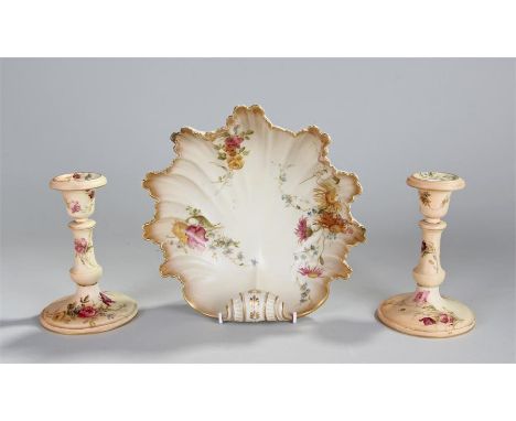 Three Royal Worcester blush porcelain pieces, to include a pair of candlesticks 16cm high, and a scallop shaped dish, 23cm wi