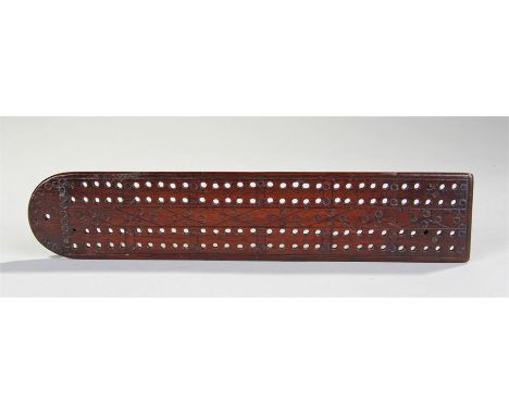 19th Century mahogany cribbage board, with geometric circle design, brass feet to the base, 24cm long