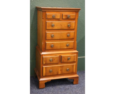 Yew wood multi drawer bedside chest raised on bracket supports, 77 cm high x 38 cm wide. 