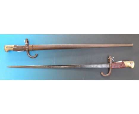 A French bayonet in scabbard, marked St Etiene 1875 to back of blade, together with a similar example dated 1879