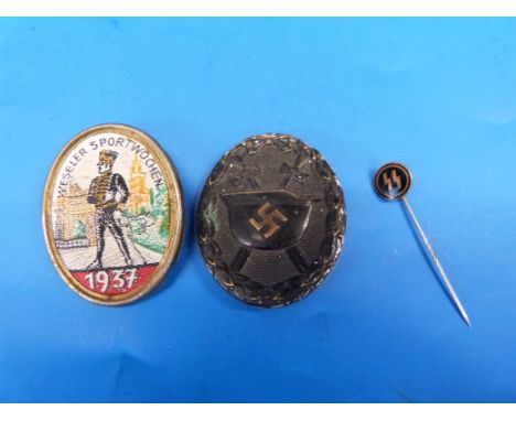 A Nazi SS wound badge together with an SS stick pin and a German embroidered badge marked Weseler Sportwochen 1937