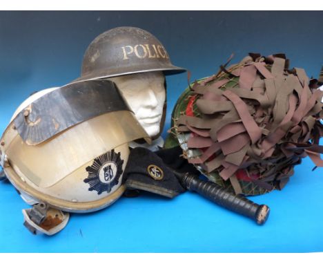 A collection of four helmets including a riot helmet, a Military Police helmet, an American Vietnam era helmet, a WW2 police 