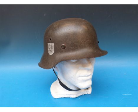 A German WW2 SS combat helmet with logo to right hand side, stamped to interior 342 with period inscription to leather liner 