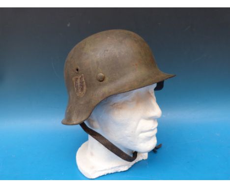 A German WW2 SS combat helmet with logo to right hand side and stamped to interior (possibly FF 64 and 35877)