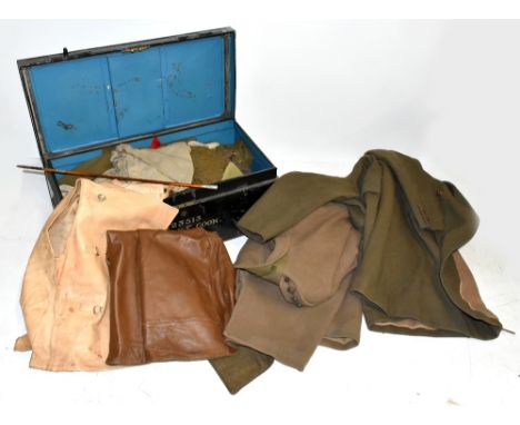 A collection of military uniform and accessories including two woolen great coats, two leather waistcoats possibly for tank r