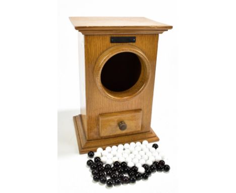 A 20th century light oak Masonic voting box with single drawer, with assortment of voting balls,&nbsp;height 29cm.Additional 