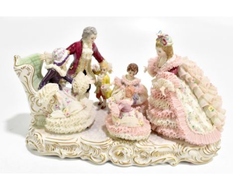 IRISH DRESDEN; a ceramic figure group depicting a gentleman and boy beside two ladies and two girls, raised on oval plinth ba