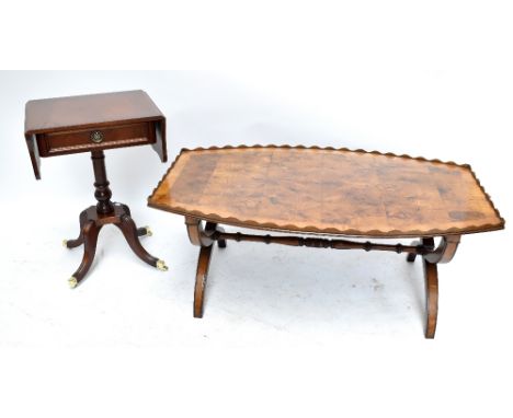 A large reproduction yew wood coffee table of rounded rectangular form with shaped gallery and square sectioned crossover end