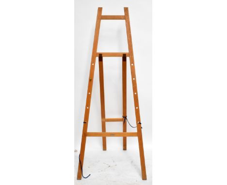 An artist’s easel with indistinct label, height 181cm.Additional InformationScuffs scrapes and general wear throughout.  