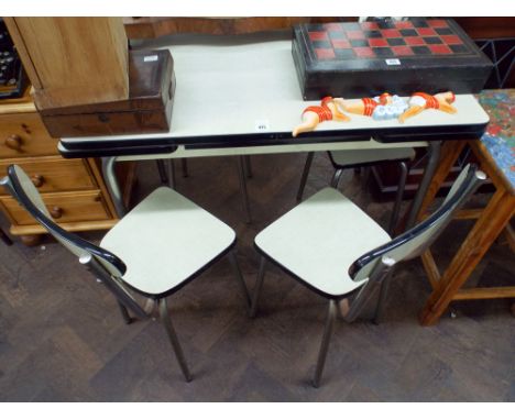 A 1960's Formica top draw leaf dining table with three matching tubular framed chairs 