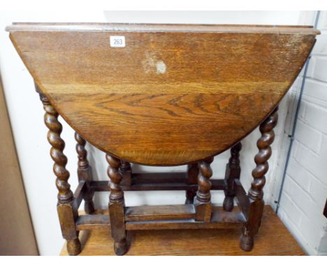 An oval oak gate leg table on barley twist legs, 2'6 wide