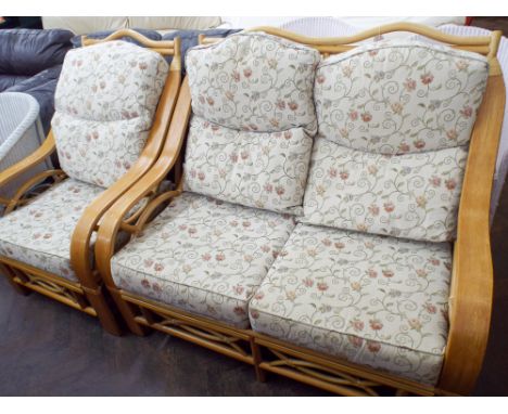 A light oak and bamboo framed two seater settee with cream floral patterned cushions and one matching chair 