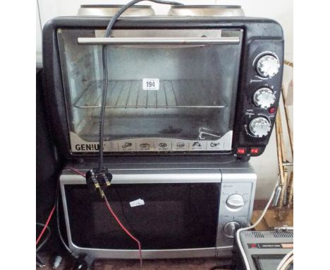 A microwave oven in a silver case and an Genius table top grill with two electric rings 