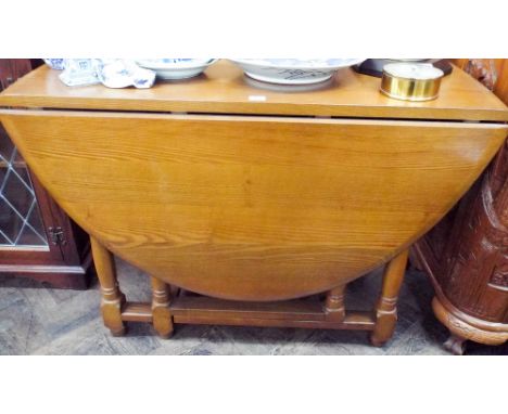 An Ercol style oak gate leg dining table on turned legs 