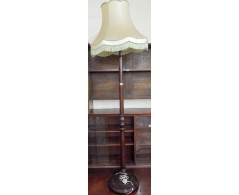 A turned mahogany standard lamp with cream shade 