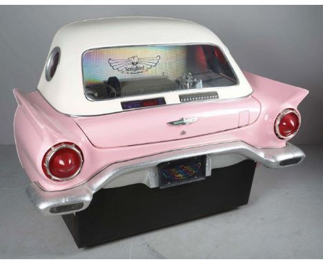 This rare jukebox has a pink 1957 Ford Thunderbird style fiberglass body with a white top that fits flush against a wall. It 