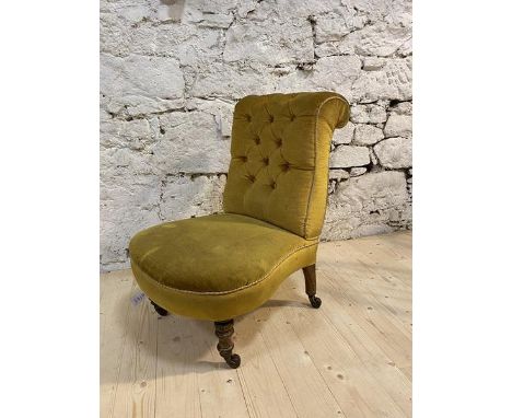 A Victorian slipper chair with scrolled button back, on turned front supports, terminating in castors, (78cm x 47cm x 66cm)