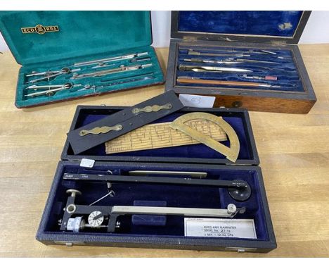 A collection of scientific / geometric equipment including dividers, a slide rule, a set of compasses, and a fixed arm planim