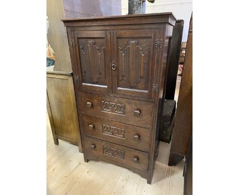 A 1920's / 30's oak Gothic revival cabinet and chest, the rectangular top over two panel doors, each with linen fold reliefs,