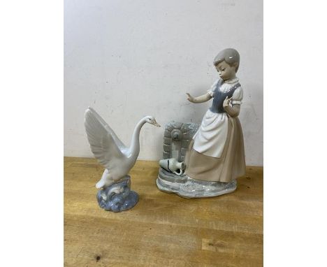 A Spanish Nao figure of a young girl by a well with broken vase, (30cm high), and a figure of a swan (2)