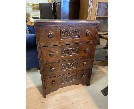 A 1920's / 30's oak Gothic revival chest of drawers, the caddy top with moulded edge over four drawers, each with a panel hav