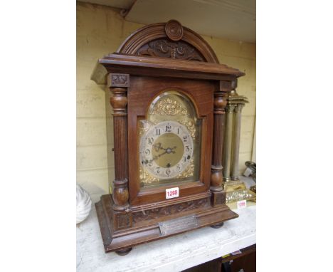An Edwardian carved walnut mantel clock, striking on gongs, 46.5cm high, with pendulum.&nbsp; 