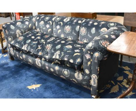 An Edwardian Chesterfield Three-Seater Sofa, upholstered in printed blue velour, raised on carved block supports with castors