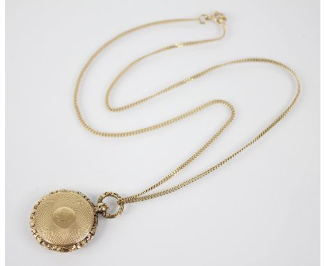 A Victorian gold coloured memorial locket pendant, of circular form, the central cartouche with monogrammed initials, to an e