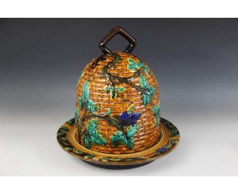 A majolica cheese bell in the manner of Minton, modelled as a bee skep entwined with fruiting vines, impressed faux "MINTON" 