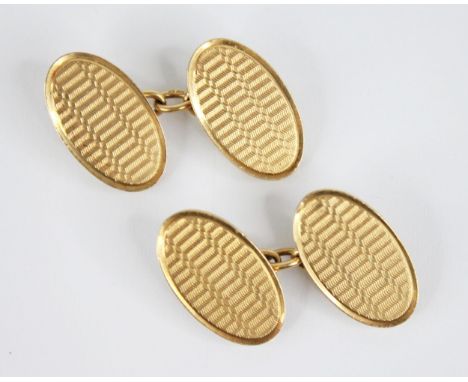 A pair of George V 18ct gold cufflinks, each designed as two panels of oval form with engine turned detail, 20mm x 12mm, mark