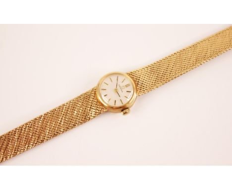 A lady's Omega 9ct gold wristwatch, the round pearlescent dial with baton markers, set to a circular gold case with manual wi