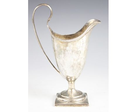 A George III silver helmet-shaped milk jug, Thomas Wallis I, London 1784, plain polished with beaded border on square foot wi