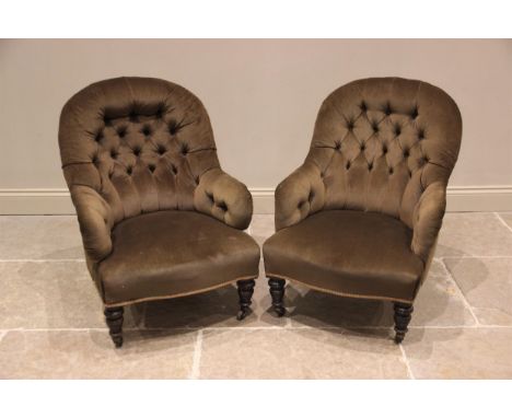 A pair of Victorian tub type chairs, upholstered in green velour fabric, each with an arched button back extending to padded 