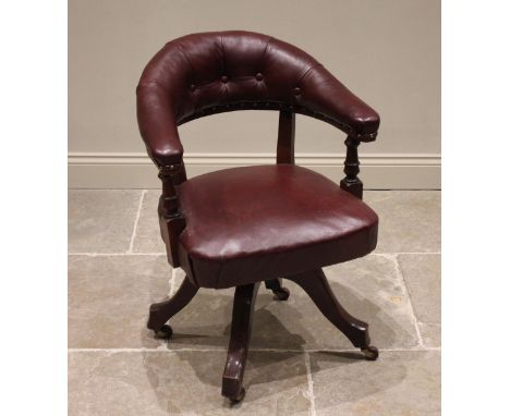 A Victorian mahogany and red leather captain's chair, the arched button back extending to padded arms upon ring turned suppor