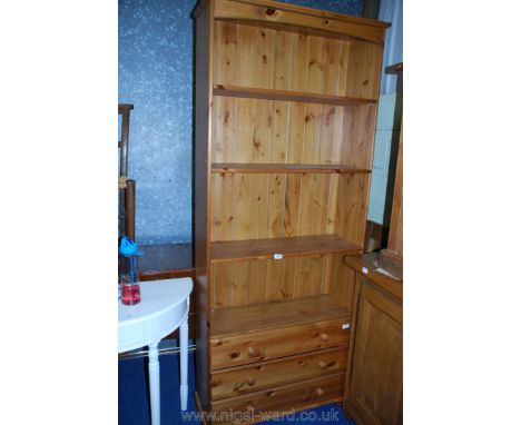 A pine three shelf/three drawer unit.