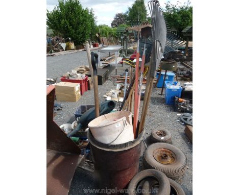 A dustbin of garden tools, sticks etc