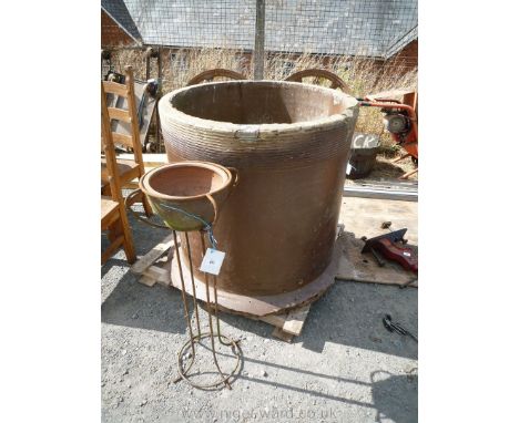 A large salt glazed stoneware pipe, wrought iron stand and planter.