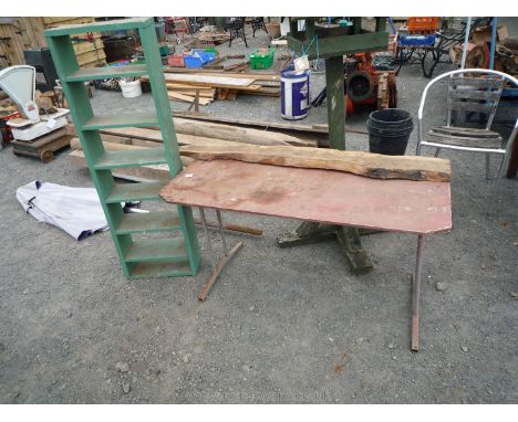 A folding table, a piece of Yew wood and green shelf unit.